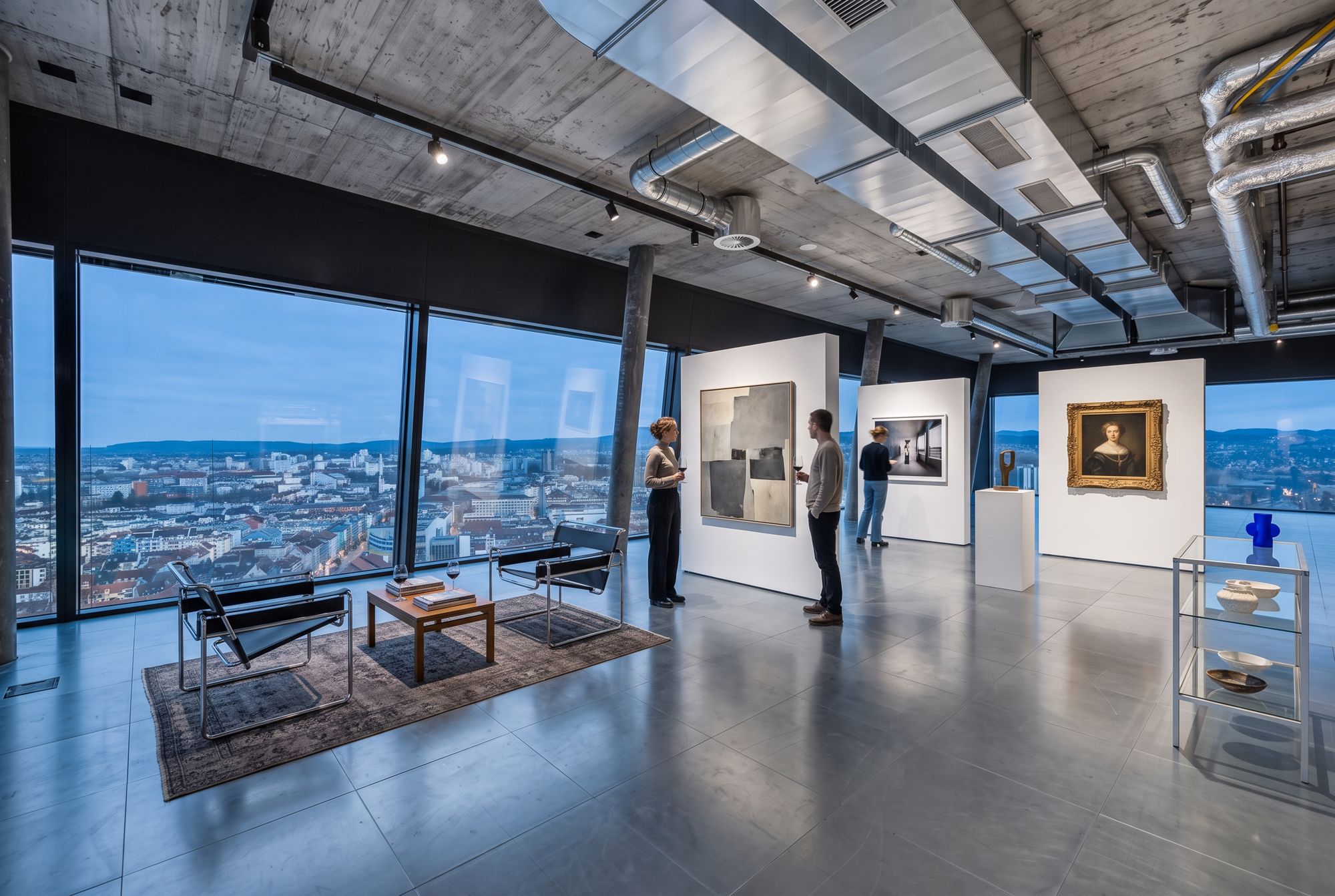 Kunstausstellung im Hauptraum mit freistehenden weissen Tafeln, Malerei, Fotografie, gerahmtem Porträt, Skulptur, Ledersesseln und kleiner Objektvitrine bei einer Vernissage